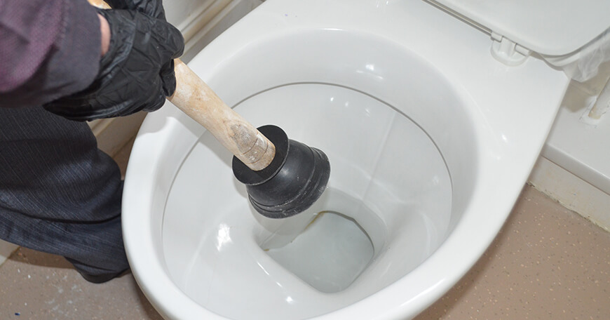 A toilet plunger being used