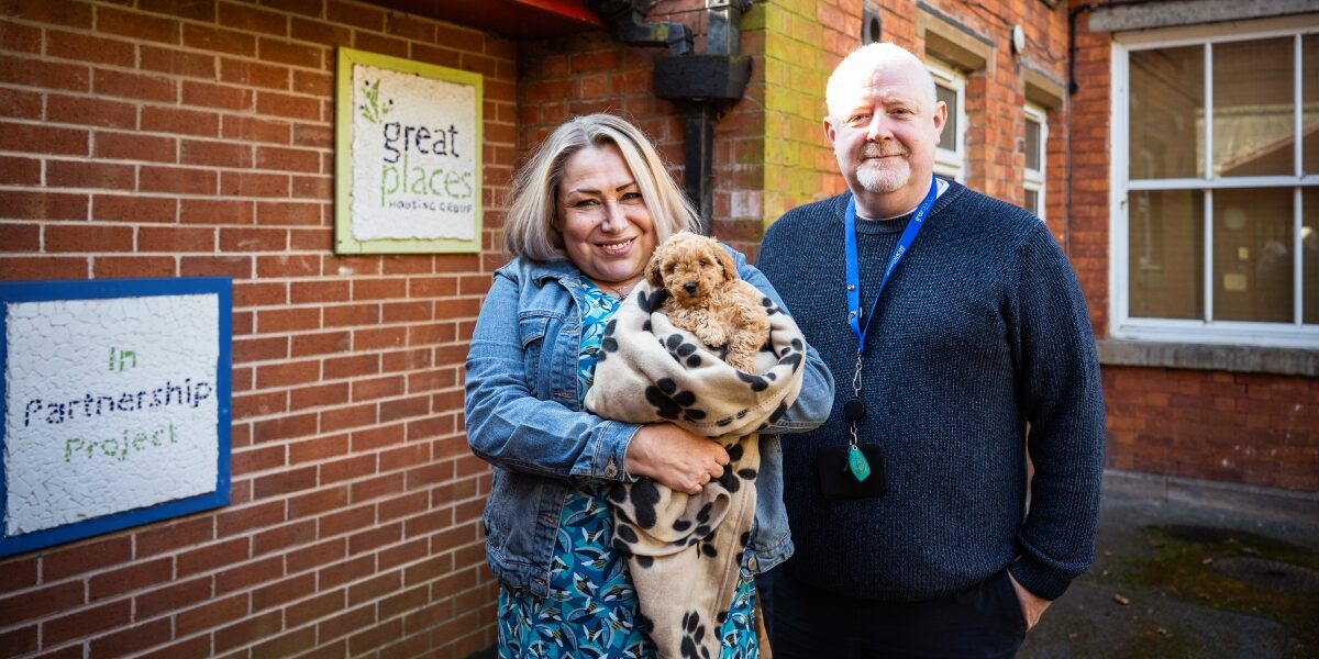 Victoria, IPP customer holding her dog next to Floating Support Worker, Jake.