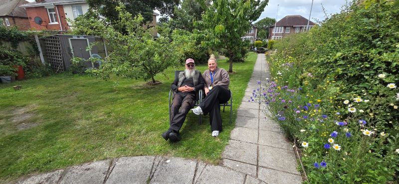Two people sat in a garden